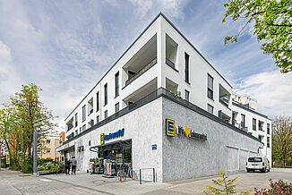 Modern mixed-use neighbourhood with flats and the entrance to the Edeka supermarket on the ground floor.