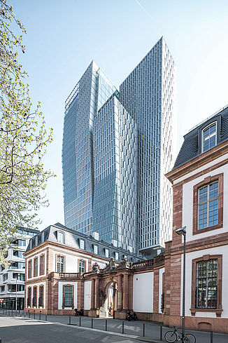 An old building stands in front of the towers of the Palais Quartier in Frankfurt.